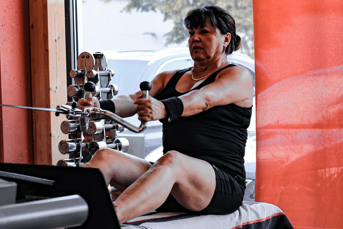 Eine Fraue beim Training am Seilzug in einem hellen Fitnessstudio